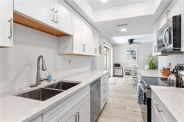 a kitchen that has a lot of cabinets in it and appliances