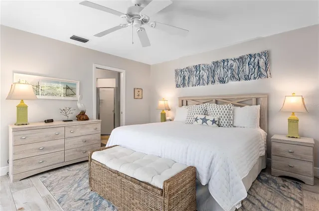 a bedroom with a large bed and a chandelier fan