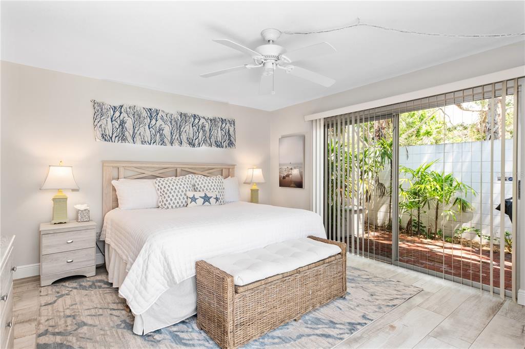 6005 Midnight Pass Road, Unit S4 Sarasota, FL 34242 - Photo 16 of 34 a bedroom with a large bed and a chandelier fan