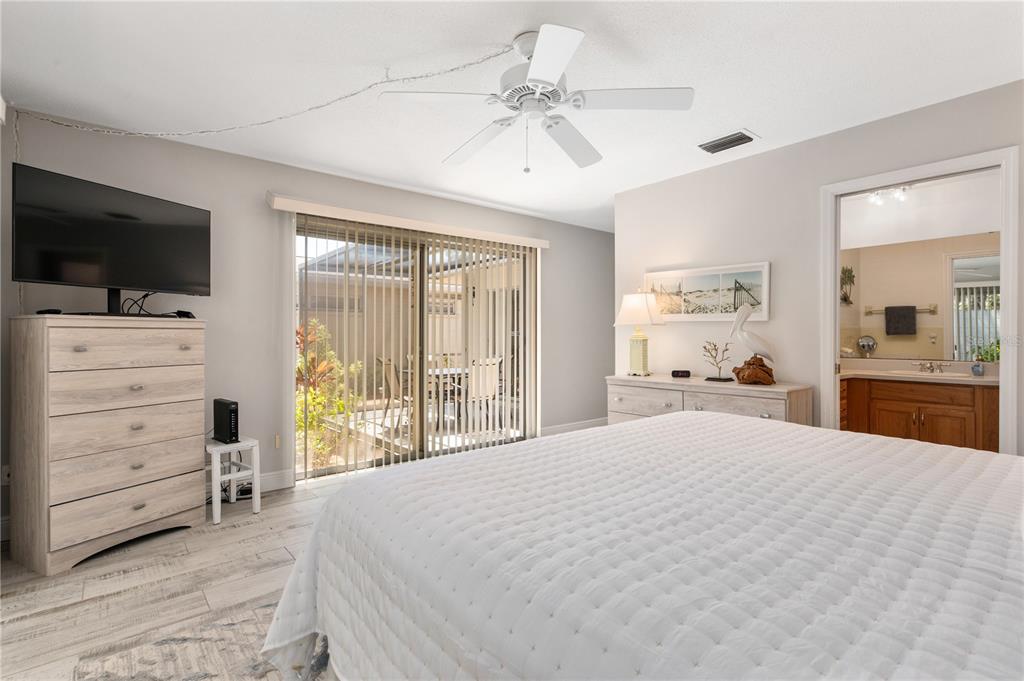 6005 Midnight Pass Road, Unit S4 Sarasota, FL 34242 - Photo 17 of 34 a spacious bedroom with a large bed and flat tv screen on dresser