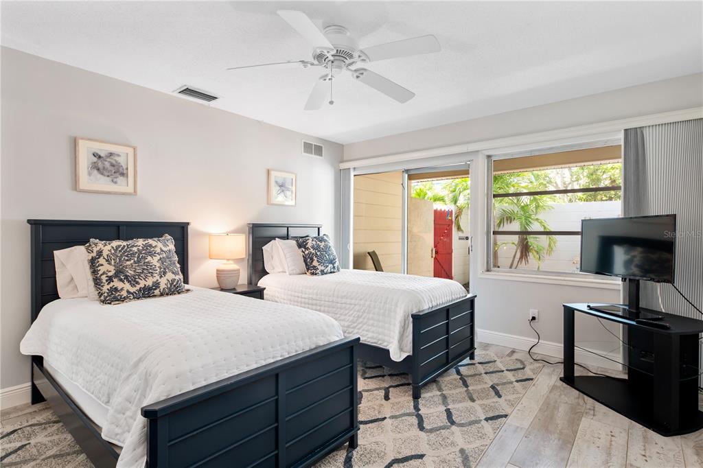 6005 Midnight Pass Road, Unit S4 Sarasota, FL 34242 - Photo 19 of 34 a bedroom with a bed and a flat screen tv