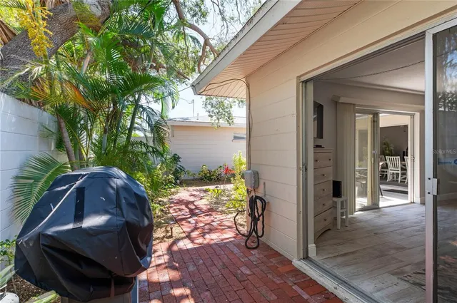 a patio with table and chairs and potted plants