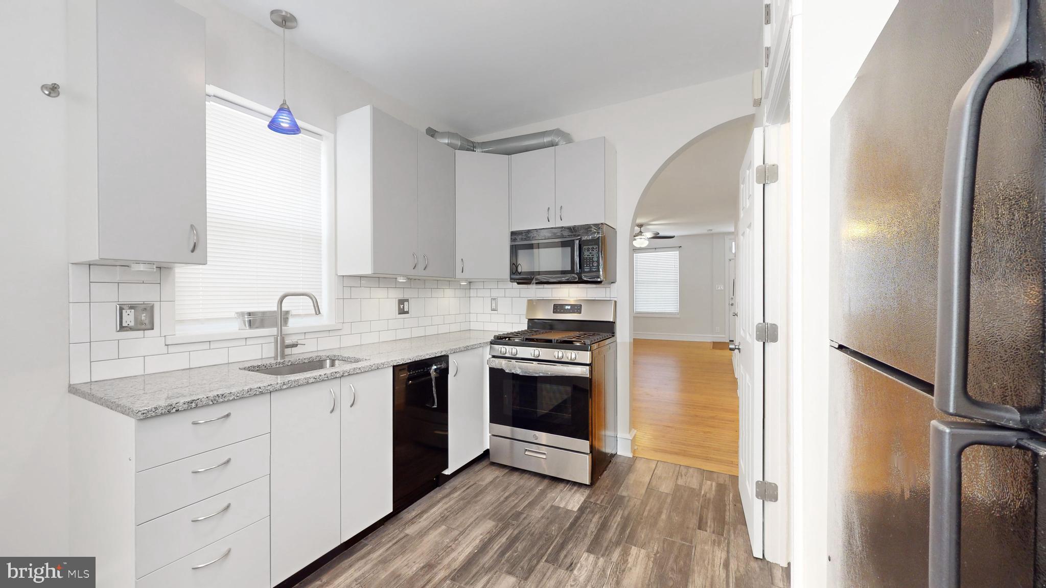 5142 Ranstead Street Philadelphia, PA 19139 - Photo 8 of 16 a kitchen with stainless steel appliances granite countertop a sink stove and refrigerator