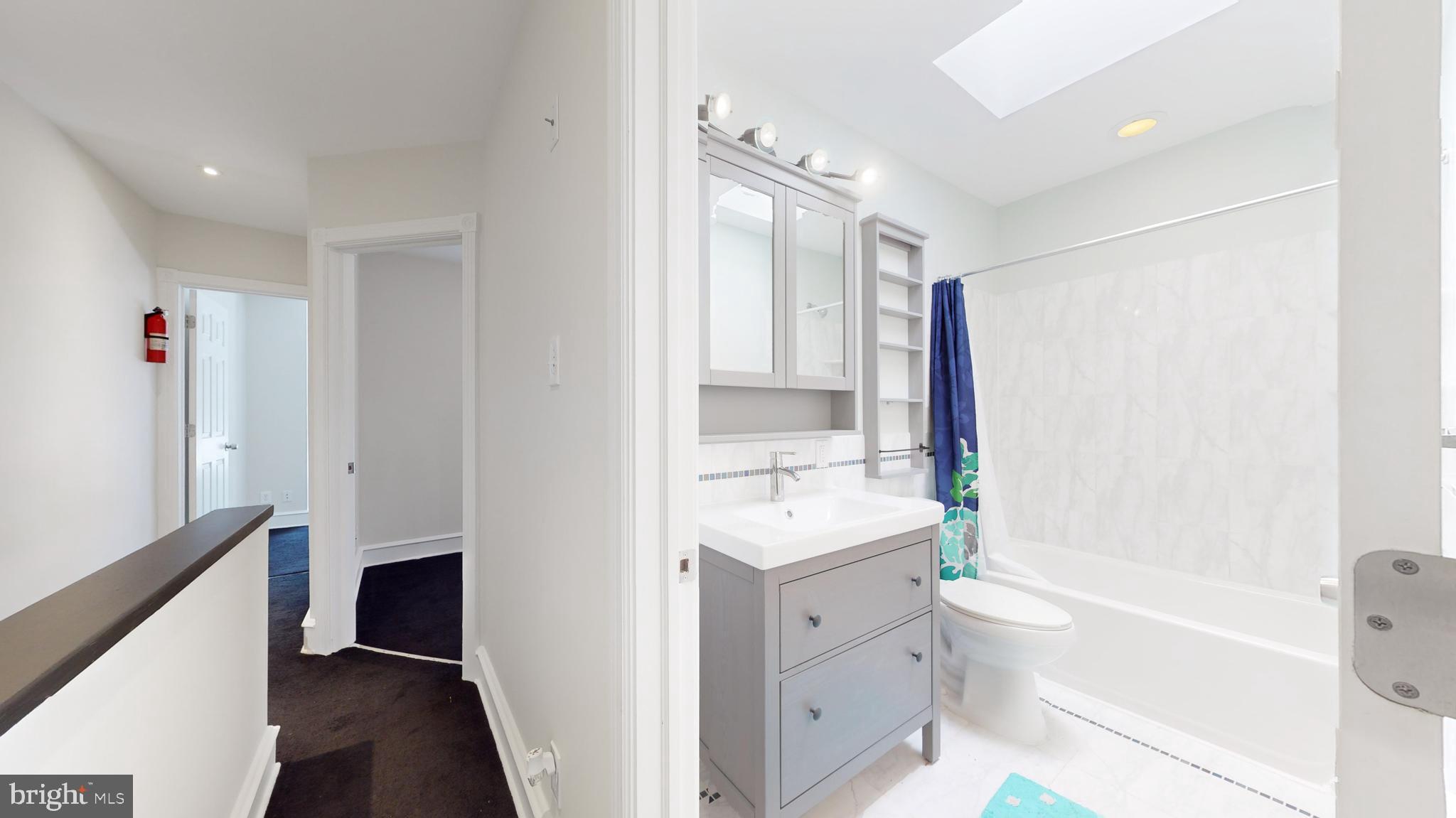 5142 Ranstead Street Philadelphia, PA 19139 - Photo 9 of 16 a bathroom with a bathtub shower sink vanity and a mirror