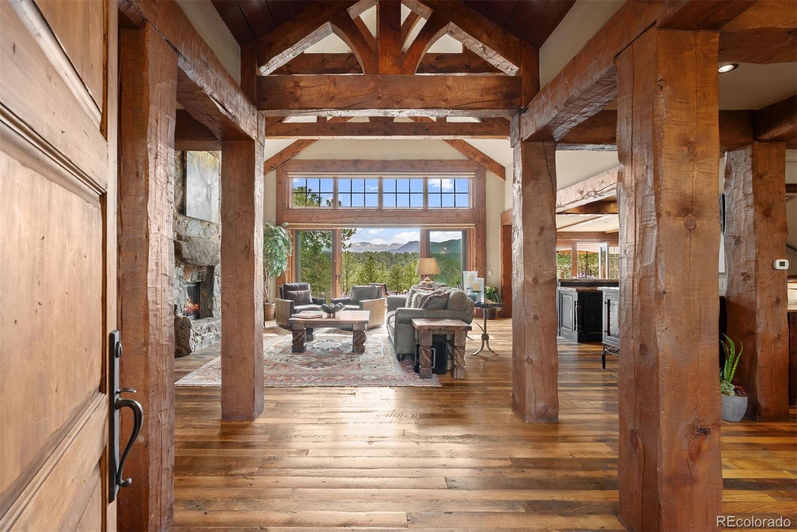 2929 Highlands View Road Evergreen, CO 80439 - Photo 3 of 50 a view of a living room with furniture wooden floor and a floor to ceiling window