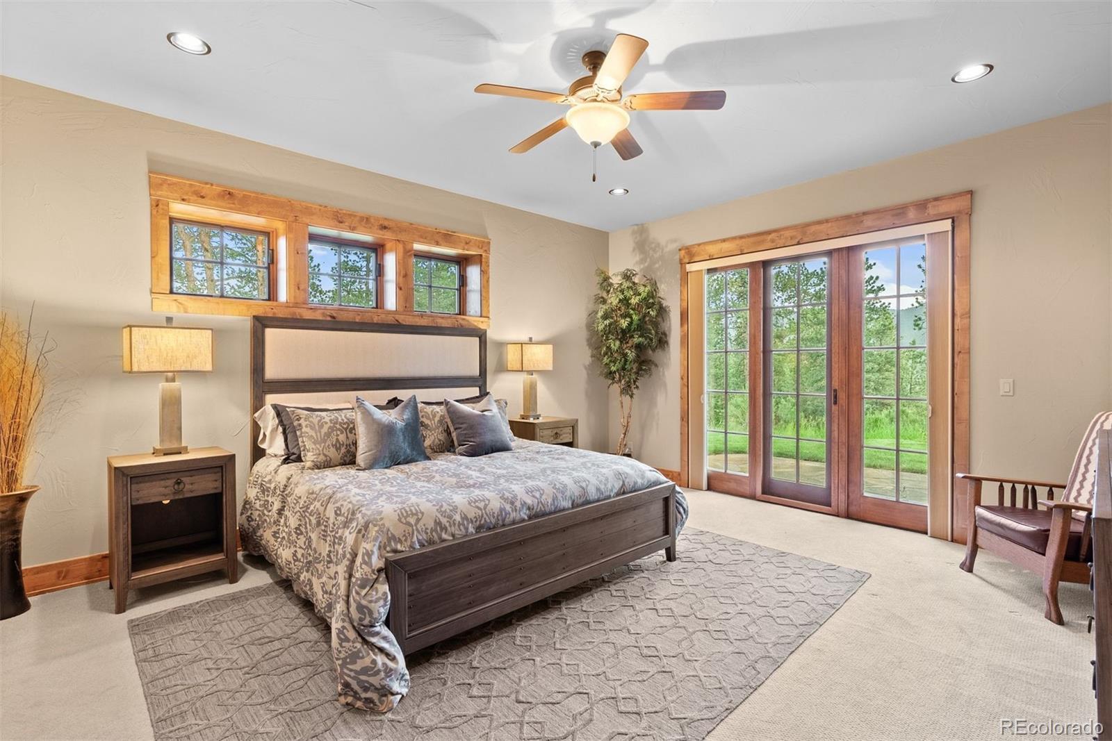 2929 Highlands View Road Evergreen, CO 80439 - Photo 39 of 50 a bedroom with a large bed and a chandelier