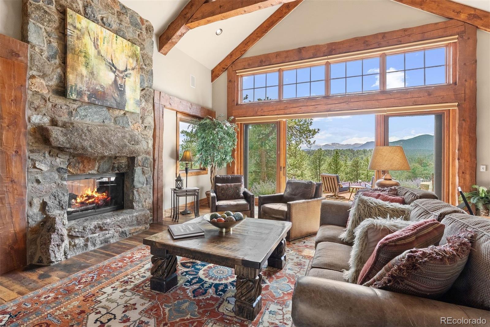 2929 Highlands View Road Evergreen, CO 80439 - Photo 4 of 50 a living room with furniture a fireplace and large windows