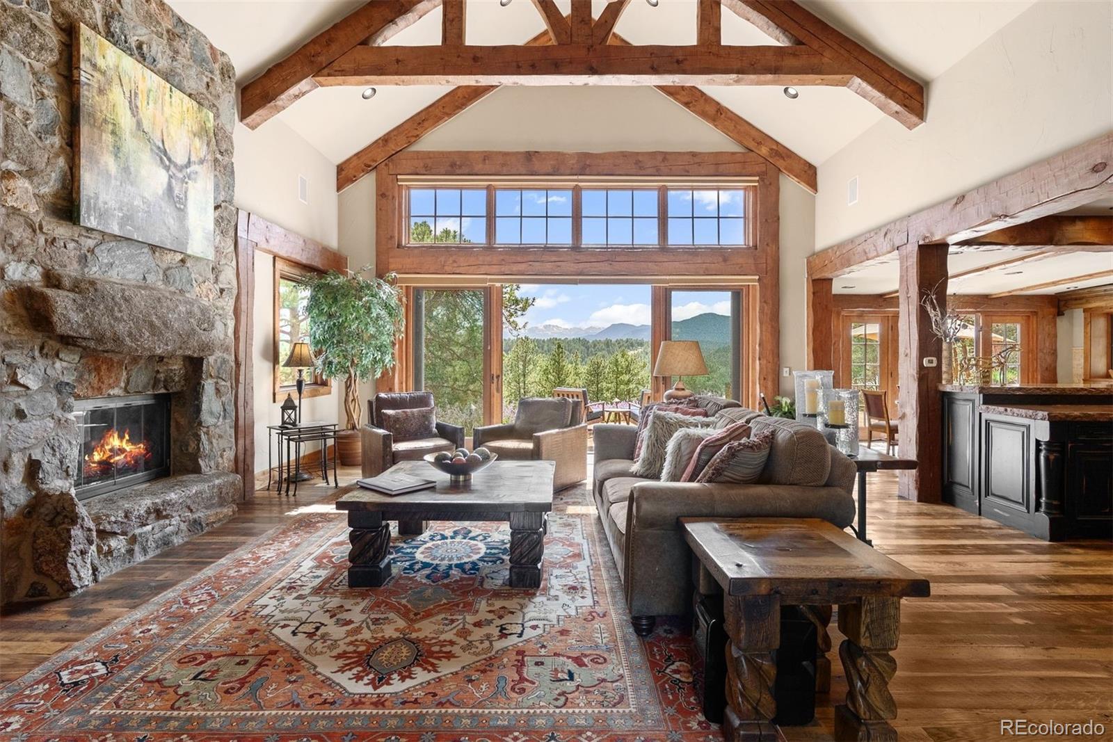 2929 Highlands View Road Evergreen, CO 80439 - Photo 6 of 50 a living room with furniture and a fireplace
