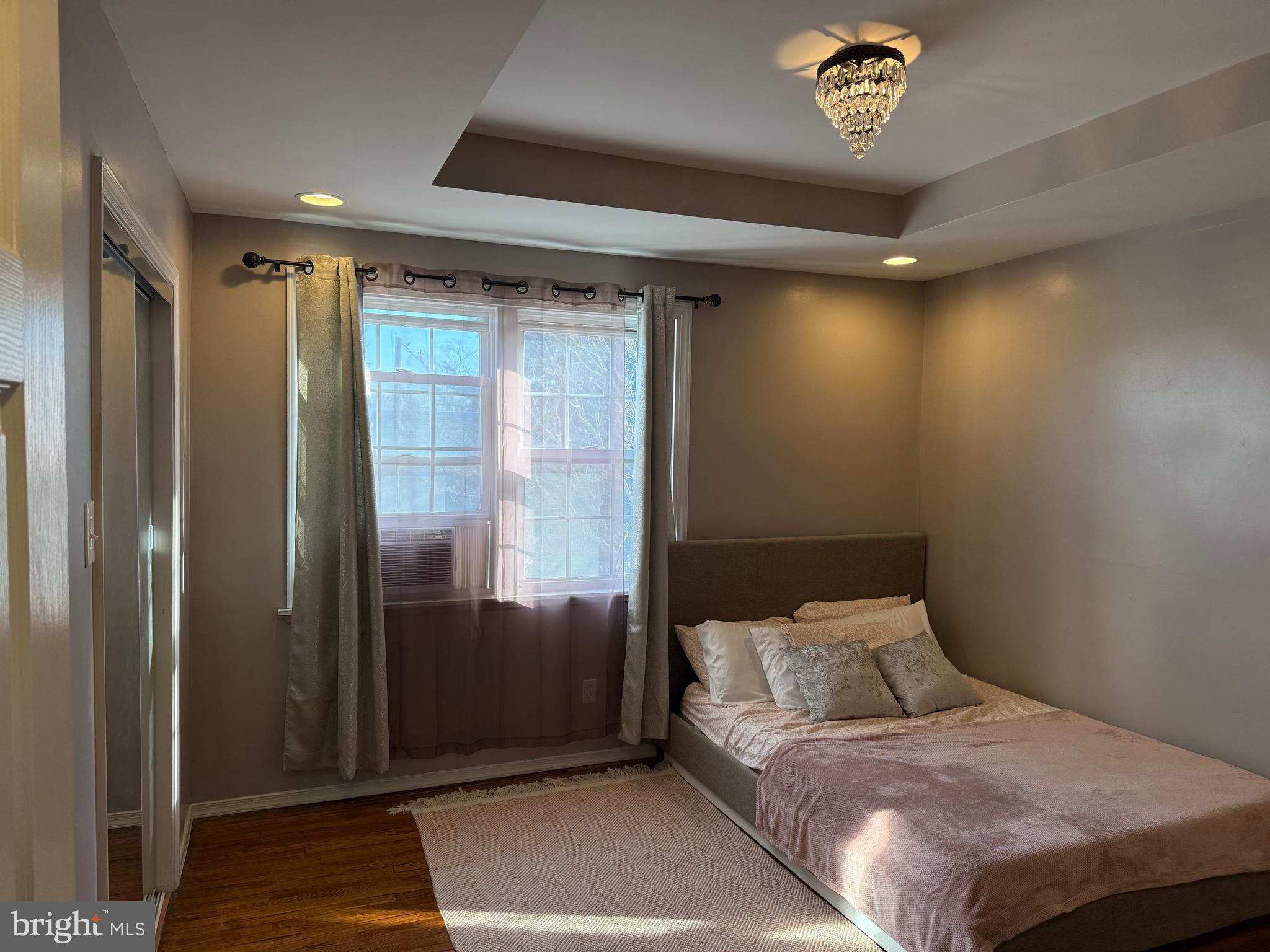 6234 Cottage Street Philadelphia, PA 19135 - Photo 5 of 16 a bedroom with a large bed and a chandelier