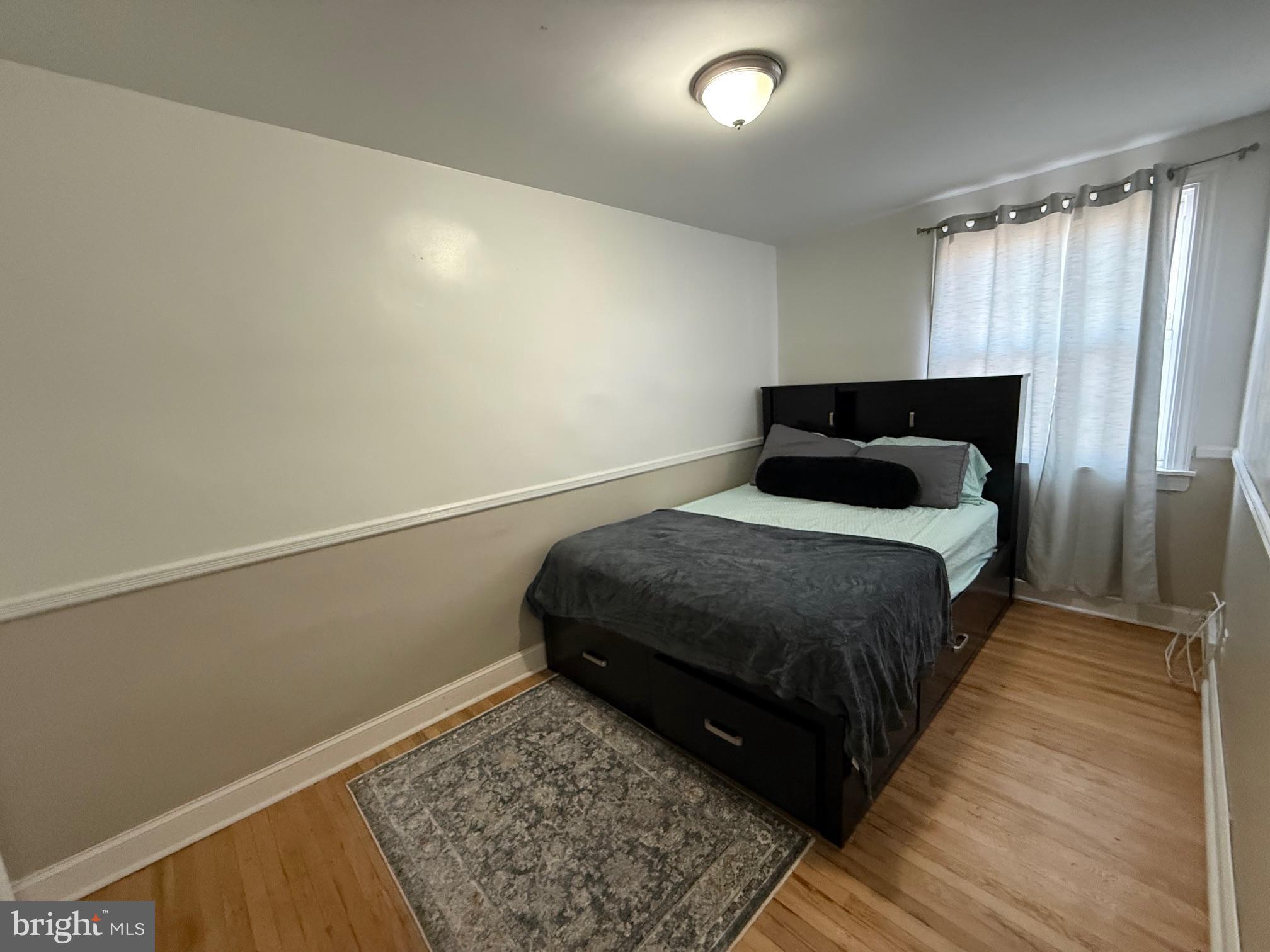 6234 Cottage Street Philadelphia, PA 19135 - Photo 8 of 16 a bedroom with a bed and a window
