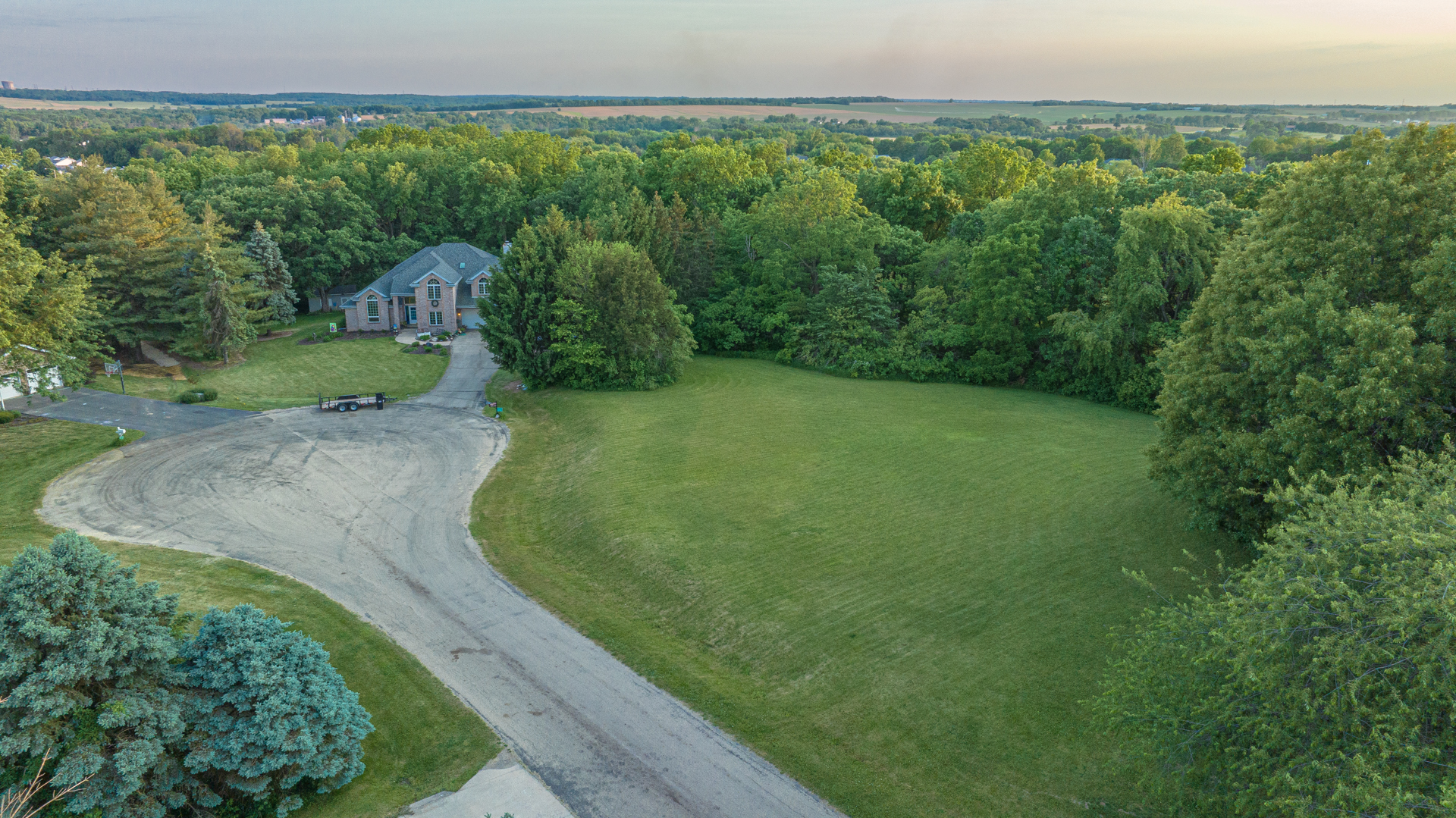 a view of a big yard with large trees