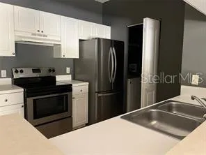 a kitchen with a refrigerator sink and cabinets