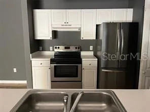 a kitchen with a refrigerator and a sink
