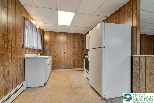 a view of a refrigerator in kitchen and wooden cabinets