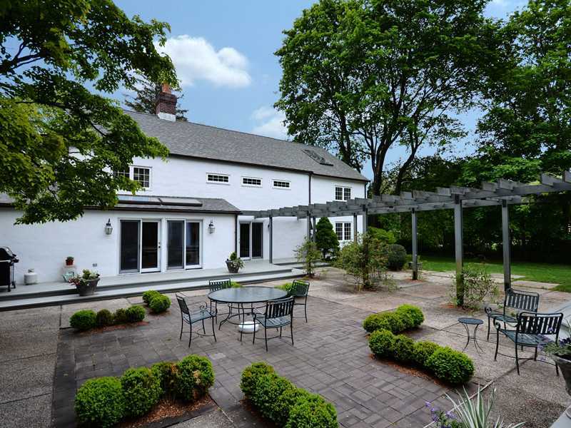 331 Hollow Tree Ridge Road Darien, CT 06820 - Photo 2 of 19 a view of a patio with table and chairs potted plants and large tree