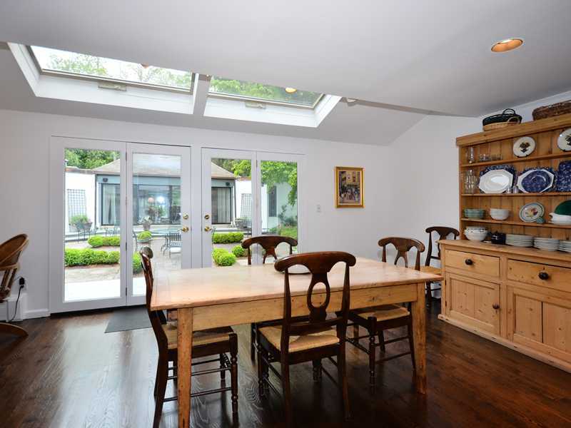 331 Hollow Tree Ridge Road Darien, CT 06820 - Photo 7 of 19 a dining room with wooden floor a chandelier a wooden table and chairs