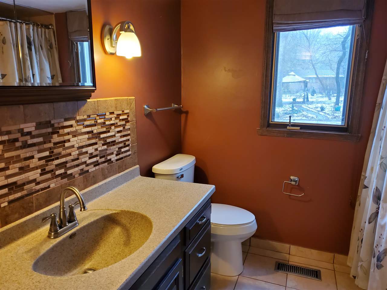 4802 Spring Creek Road Rockford, IL 61114 - Photo 9 of 25 a bathroom with a sink a toilet and a mirror