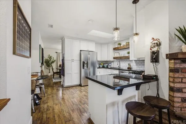 a kitchen with stainless steel appliances granite countertop a refrigerator a sink and a stove