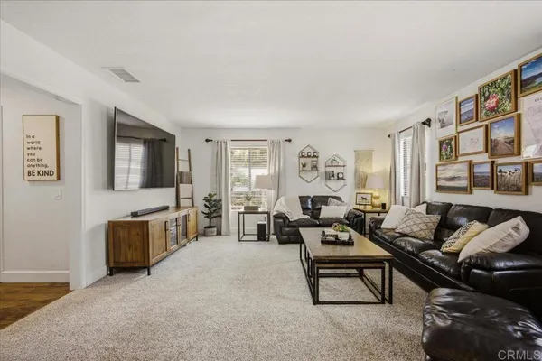 a living room with furniture large window and wooden floor