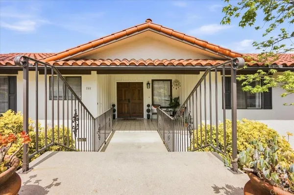 a living room with stainless steel appliances furniture a refrigerator and a sink