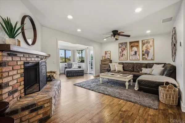 a kitchen with stainless steel appliances kitchen island granite countertop a table chairs and a refrigerator