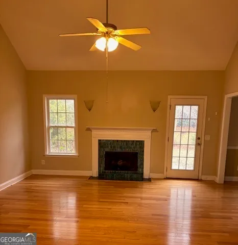 a view of an empty room with window and wooden floor
