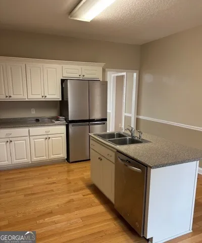 a kitchen with stainless steel appliances granite countertop a stove a sink and a refrigerator