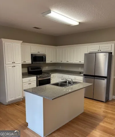 a kitchen with wooden cabinets and stainless steel appliances