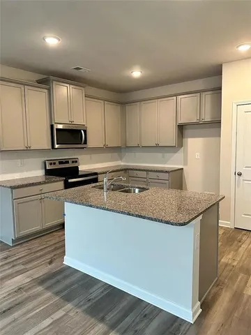 a kitchen with granite countertop a sink and steel appliances