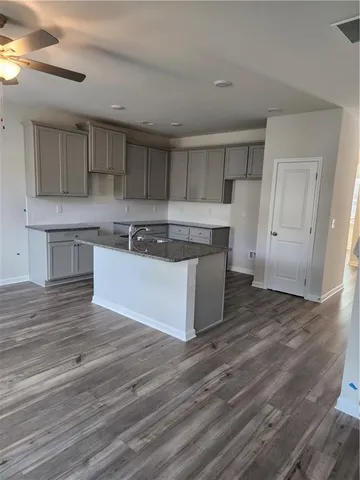 a kitchen with wooden floors and white cabinets