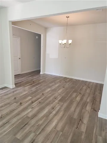 a view of a room with wooden floor and chandelier