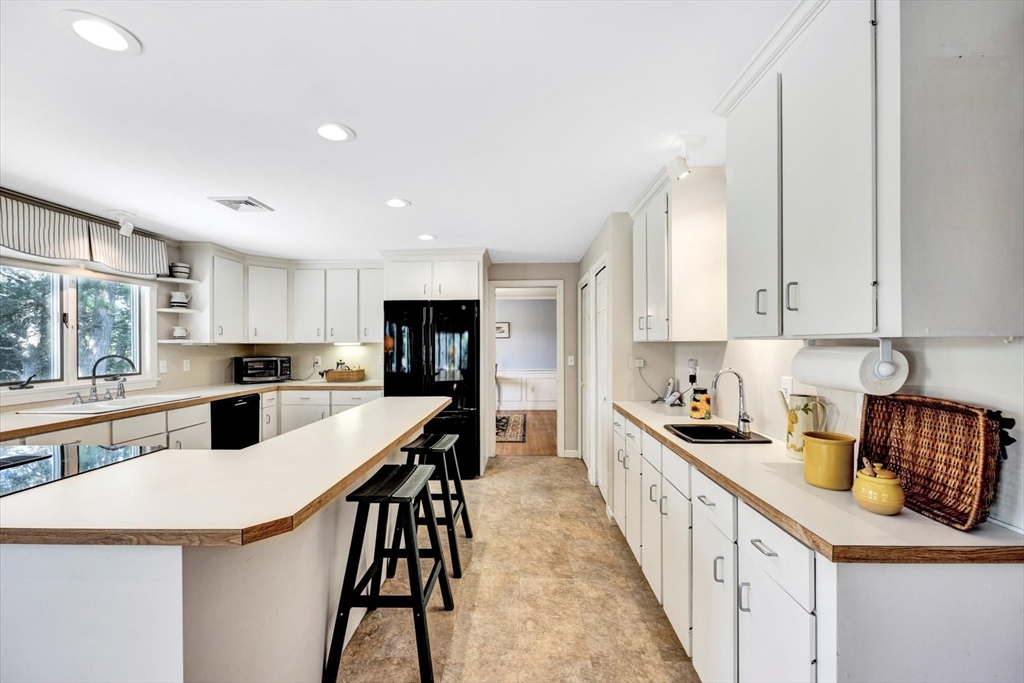 19 Babbling Brook Road Barnstable, MA 02632 - Photo 8 of 35 a kitchen with stainless steel appliances kitchen island granite countertop a stove a sink a refrigerator and white cabinets with wooden floor