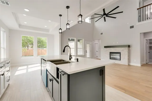 a kitchen with a stove a sink a center island and windows