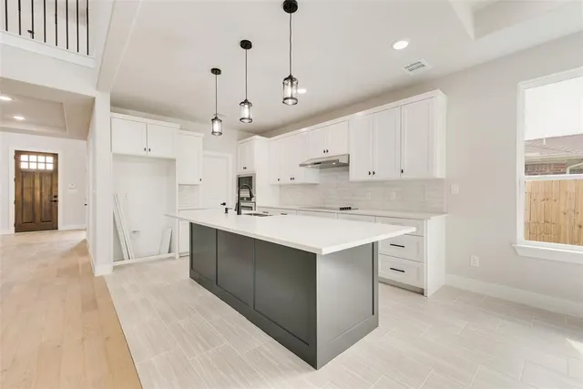 a kitchen with kitchen island a sink stainless steel appliances and cabinets