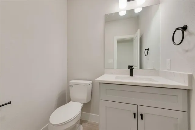 a bathroom with a toilet sink vanity and mirror