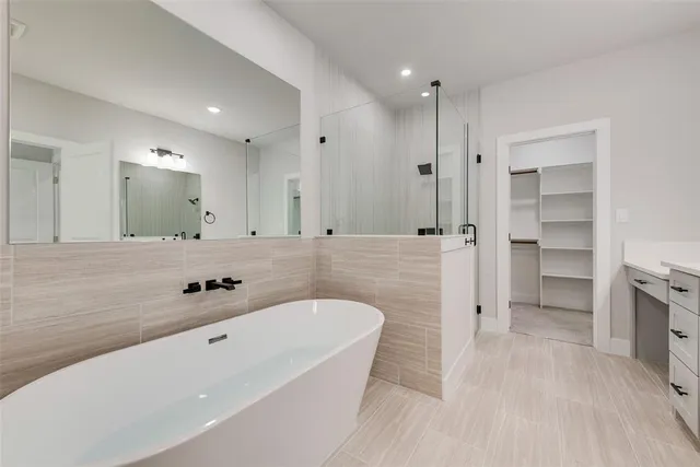 a spacious bathroom with a tub sink and mirror