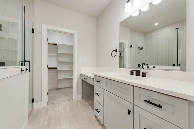 a spacious bathroom with a double vanity sink a mirror and shower
