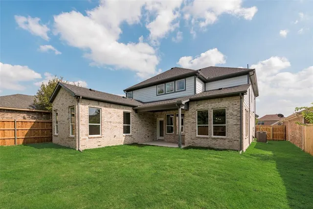 a view of a house with a large window and a yard with plants