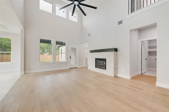 an empty room with windows and fireplace