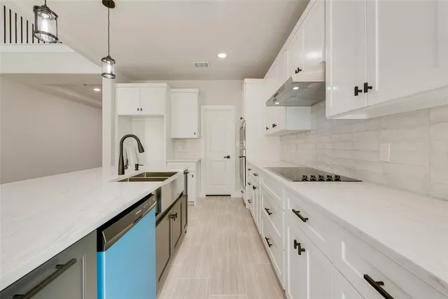 a kitchen with sink a stove and cabinets