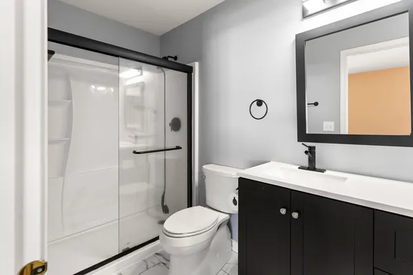 a bathroom with a sink a toilet and shower