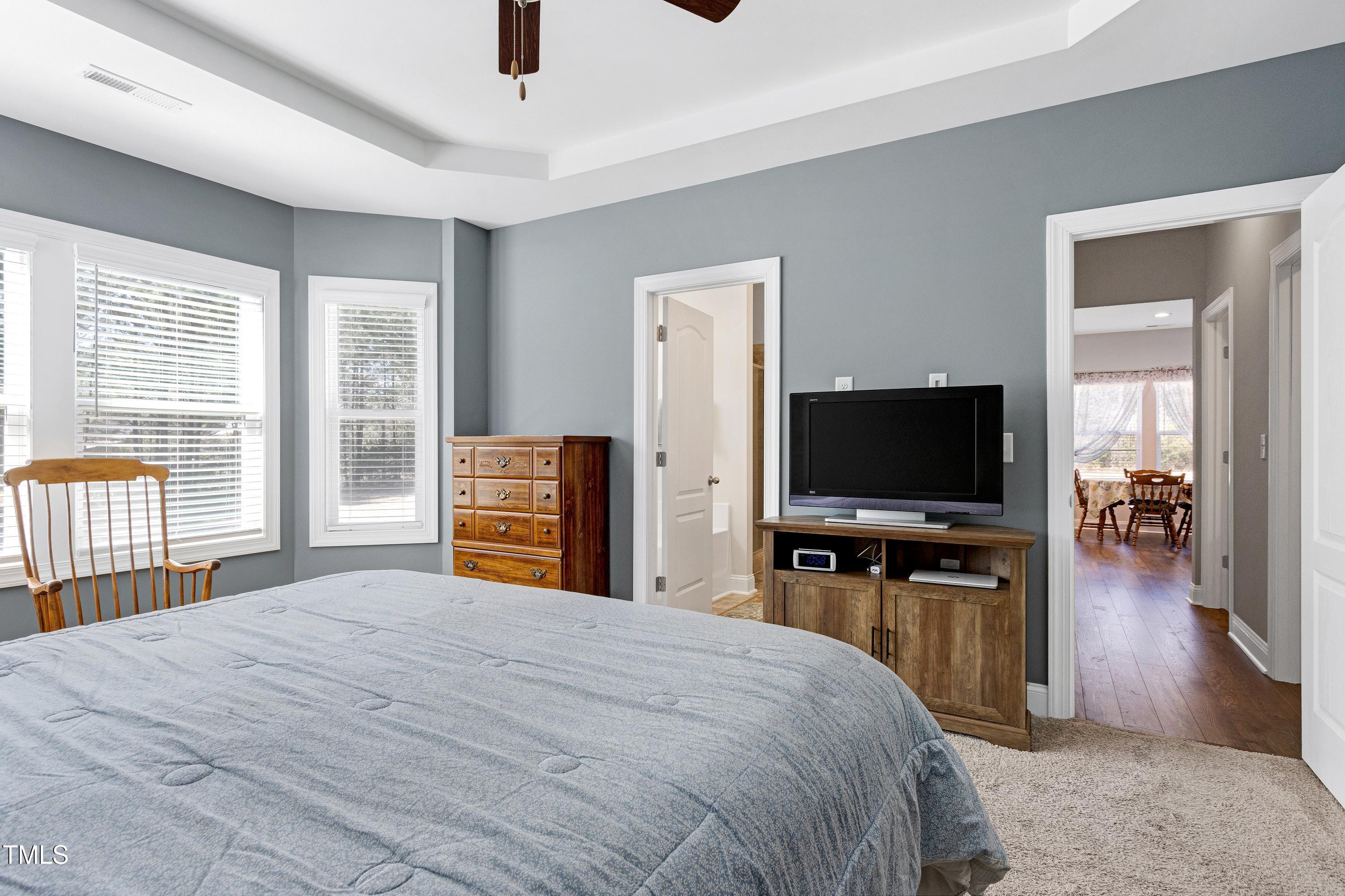 1613 Osprey Ridge Drive Willow Spring, NC 27592 - Photo 16 of 37 a bedroom with a bed and a flat tv screen on wall