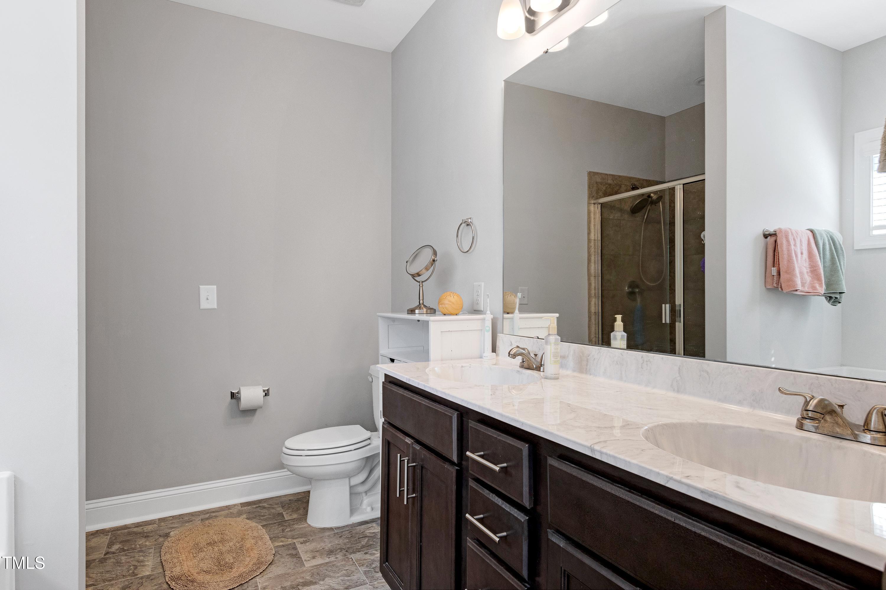 1613 Osprey Ridge Drive Willow Spring, NC 27592 - Photo 17 of 37 a bathroom with a granite countertop sink a toilet and a large mirror