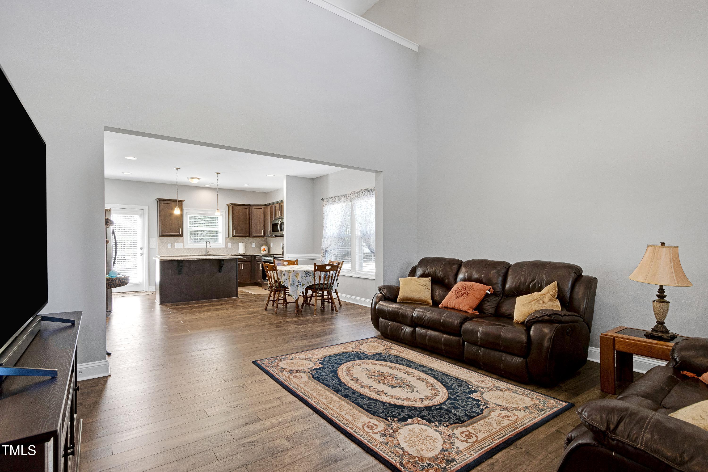 1613 Osprey Ridge Drive Willow Spring, NC 27592 - Photo 5 of 37 a living room with furniture a rug and a flat screen tv