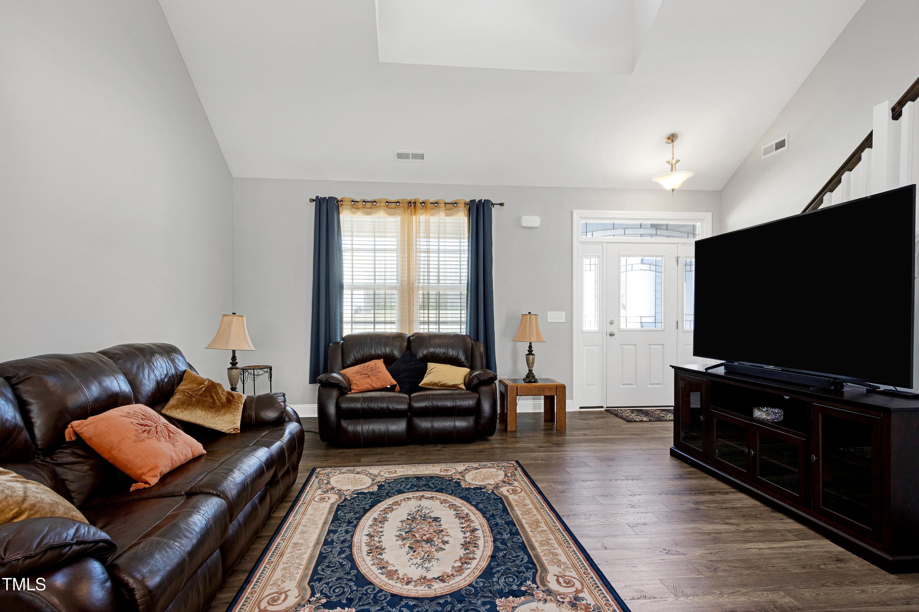 1613 Osprey Ridge Drive Willow Spring, NC 27592 - Photo 6 of 37 a living room with furniture and a flat screen tv