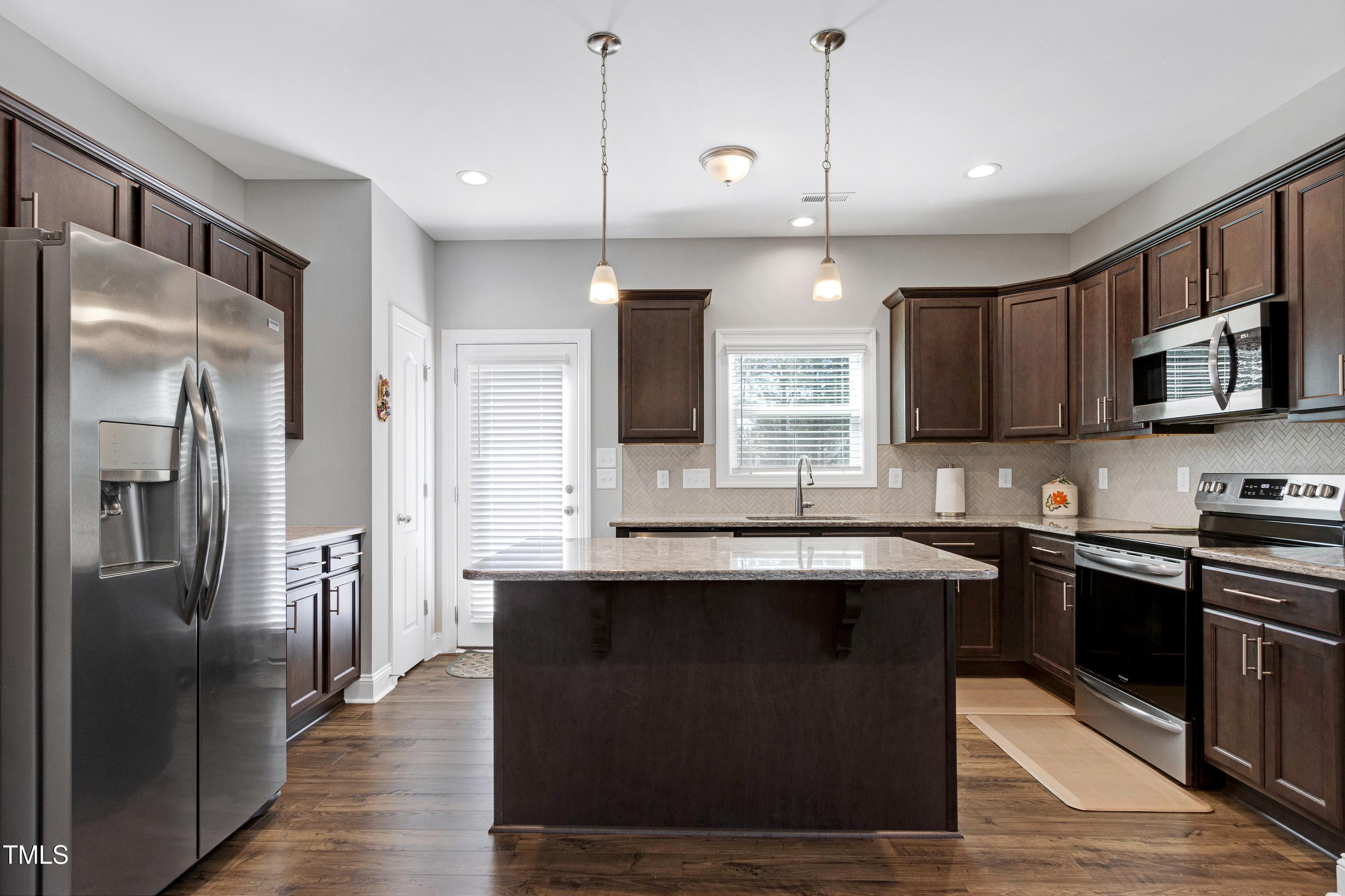 1613 Osprey Ridge Drive Willow Spring, NC 27592 - Photo 9 of 37 a kitchen with stainless steel appliances granite countertop a sink stove and refrigerator
