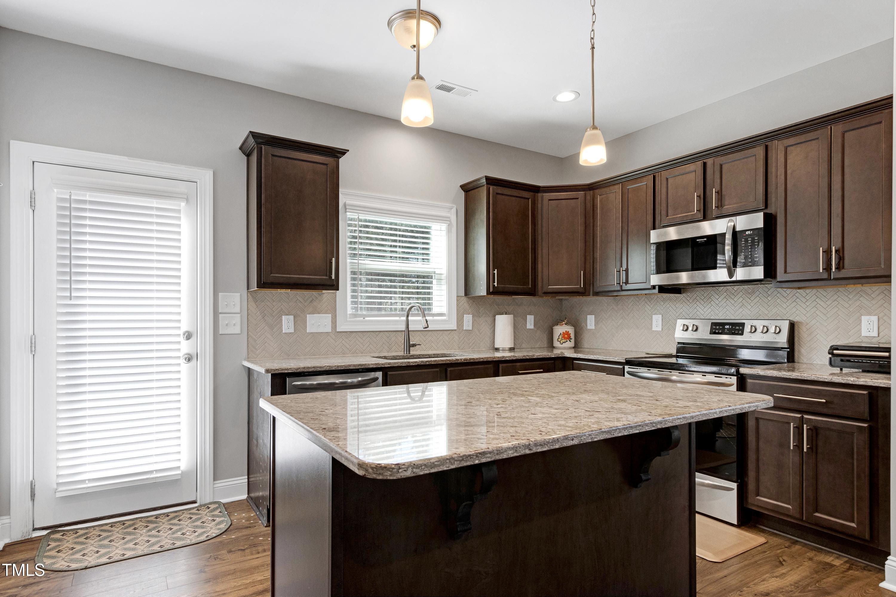 1613 Osprey Ridge Drive Willow Spring, NC 27592 - Photo 10 of 37 a kitchen with granite countertop stainless steel appliances cabinets a sink and a window