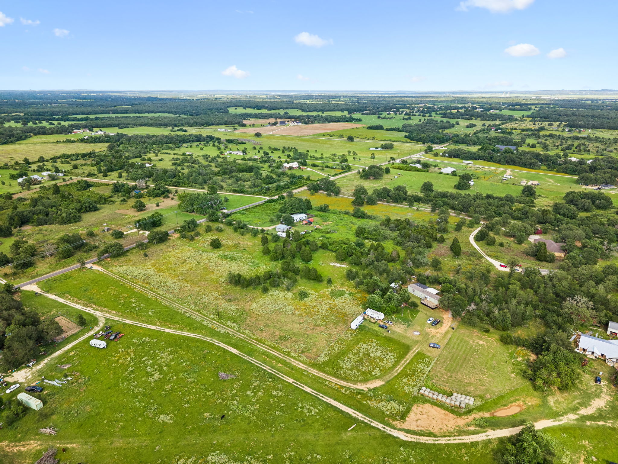 253 North County Line Road, Unit C Elgin, TX 78621 - Photo 33 of 39 Sprawling green acreage with scattered homes and natural tree lines defines this serene landscape.