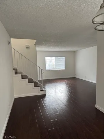 a view of a room with wooden floor and white walls