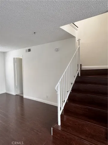 a view of staircase with wooden floor and white walls